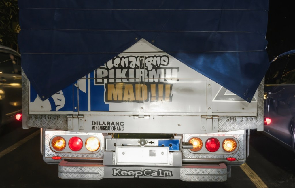 Bagian belakang truk dengan tulisan 'tenangno pikiranmu mad'